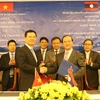 Bộ trưởng Bộ Thông tin và Truyền thông Nguyễn Mạnh Hùng (trái) và Bộ trưởng Bộ Thông tin, Văn hóa và Du lịch Lào Bosengkham Vongdala (phải) trao biên bản hợp tác đã ký kết. (Ảnh: Xuân Tú/TTXVN) 