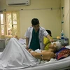Bác sỹ thăm khám bệnh nhân B.V.M. (Ảnh: PV/Vietnam+)