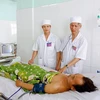 Bác sỹ Bệnh viện Quân y 211, Quân đoàn 3 chăm sóc cho bệnh nhân A Viêng. (Ảnh: Dư Toán/TTXVN)