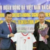 Ông Trần Quốc Tuấn; Phó Chủ tịch thường trực VFF (trái) tặng áo đấu của Đội tuyển Việt Nam cho ông Pierre Michael Littbarski, huyền thoại bóng đá Đức, Đại sứ CLB Wolfsburg. (Ảnh: Trọng Đạt/TTXVN)