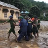 Lực lượng cứu hộ đưa em Nguyễn Minh Lâm bị đa chấn thương từ bản Sa Ná ra ngoài để chữa trị. (Ảnh: TTXVN)