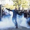 Người biểu tình bạo lực ném hơi cay trong cuộc tuần hành chống biến đổi khí hậu tại Paris, Pháp, ngày 21/9/2019. (Ảnh: AFP/TTXVN)