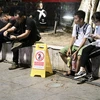 Biển báo đặt ở phố đi bộ quận Hoàn Kiếm với nội dung "Chúng tôi sẽ chụp ảnh, quay phim, hành vi xả rác bừa bãi. (Ảnh: Hồng Vĩ/TTXVN)