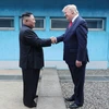 Tổng thống Mỹ Donald Trump (phải) và nhà lãnh đạo Triều Tiên Kim Jong-un trong cuộc gặp thượng đỉnh tại làng đình chiến Panmunjom trong Khu phi quân sự (DMZ) ngày 30/6/2019. (Ảnh: AFP/ TTXVN)