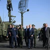 Tổng thống Vladimir Putin cùng các quan chức cấp cao quân đội Nga thăm trung tâm bay thử nghiệm quân sự ở Akhtubinsk, Nga, ngày 14/5. (Ảnh: AFP/TTXVN) 