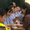Cô giáo Nguyễn Thị Thu Anh, hiệu trưởng Trường THCS và THPT Nguyễn Tất Thành trao quà cho các đồng nghiệp đang điều trị tại Bệnh viện K Trung ương, cơ sở Tân Triều. (Ảnh: PV/Vietnam+)