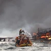 Lực lượng phòng vệ bờ biển Hàn Quốc nỗ lực dập lửa trên tàu cá bị cháy ở ngoài khơi phía đông đảo Jeju, ngày 19/11/2019. (Ảnh: YONHAP/TTXVN)