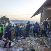 Nhân viên cứu hộ làm nhiệm vụ tại hiện trường vụ tai nạn máy bay của hãng Bek Air ngày 27/12. (Ảnh: AFP/TTXVN)