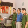 Cơ quan Cảnh sát điều tra Công an tỉnh Trà Vinh tống đạt quyết định khởi tố bị can, bắt tạm giam Trầm Ngọc Long. (Ảnh: Thanh Hòa/TTXVN)
