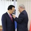 Đại sứ Việt Nam tại Hàn Quốc Nguyễn Vũ Tú trao Huân chương Lao động hạng Bacho ông Kim Kwan Yong. (Ảnh: Mạnh Hùng/TTXVN)