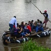Người di cư vượt sông Tecun Uman ở Guatemala để tới Ciudad Hidalgo, bang Chiapas, Mexico, trong hành trình tới Mỹ, ngày 8/6/2019. (Ảnh: AFP/TTXVN)