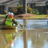 Nhân viên công ích di chuyển bằng thuyền để tắt điện trong những ngôi nhà bị ngập lụt ở Jackson, bang Mississippi.(Nguồn: nytimes.com)