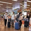 Du khách đeo khẩu trang để phòng tránh lây nhiễm COVID-19 tại sân bay quốc tế Changi, Singapore, ngày 30/1/2020. (Ảnh: AFP/ TTXVN)