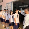 Trường THPT Vĩnh Long (thành phố Vĩnh Long, Việt Nam) đo thân nhiệt cho học sinh ngày 2/3. (Ảnh: Lê Thúy Hằng/TTXVN)