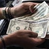  Người dân sử dụng đồng đô la Mỹ để thanh toán tại nhà hàng ở Caracas, Venezuela, ngày 18/3/2019. Ảnh: AFP/ TTXVN 