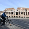 Người dân đeo khẩu trang để phòng tránh lây nhiễm COVID-19 tại Rome, Italy, ngày 22/3/2020. (Ảnh: THX/TTXVN)