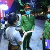 Lực lượng chức năng phường Nguyễn Du đến nhắc nhở các cửa hàng đóng cửa theo quy định. (Ảnh: Minh Quyết/TTXVN)