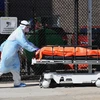 Nhân viên y tế chuyển thi thể bệnh nhân nhiễm COVID-19 tới nhà xác dã chiến bên ngoài bệnh viện ở Brooklyn, New York (Mỹ) ngày 2/4/2020. (Ảnh: AFP/TTXVN)