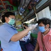 Nhân viên kiểm tra thân nhiệt của người dân tại một trạm kiểm soát ở Bangkok, Thái Lan ngày 26/3/2020, trong nỗ lực ngăn chặn sự lây lan của dịch COVID-19. (Ảnh: THX/TTXVN)
