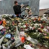 Một nhân viên của một cửa hàng hoa tiêu hủy những bông hoa chưa bán ở Saint Petersburg. (Nguồn: channelnewsasia.com)