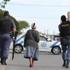 Cảnh sát Nam Phi mang hàng hóa cho một cụ già trên đường đi chợ về. (Ảnh: TTXVN phát)