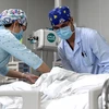Nhân viên y tế chăm sóc bệnh nhân mắc COVID-19 tại một bệnh viện ở Hà Nam, Trung Quốc ngày 26/4/2020. (Ảnh: THX/TTXVN)
