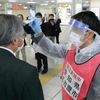 Nhân viên y tế Nhật Bản đeo tấm che mặt kiểm tra thân nhiệt người dânđể ngăn chặn sự lây lan của dịch COVID-19. (Ảnh: Kyodo/TTXVN)