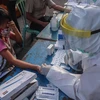 Nhân viên y tế lấymẫu máu xét nghiệm nhanh COVID-19 cho trẻ em tại Surabaya, Đông Java, Indonesia ngày 13/5/2020. (Ảnh: THX/TTXVN)