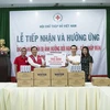 Đại diện AB InBev trao lô hàng nước sạch cho đại diện Hội Chữ Thập đỏ Việt Nam để chuyển đến những người dân vùng hạn mặn. (Ảnh: PV/Vietnam+)