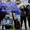 Người biểu tình giơ cao khấu hiệu và pháo sáng tại Quảng trường Nghị viện London trong một cuộc biểu tình chống phân biệt chủng tộc sáng 7/6.(Nguồn: Reuters)