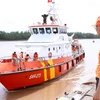 Lực lượng cứu hộ đưa thuyền viên bị nạn của tàu cá TH 90282 TS về bờ. (Ảnh: Trần Hoàng Ngọc/TTXVN)