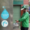 Người dân sử dụng nước ở trụ nước sạch miễn phí được đặt tại quận Hoàn Kiếm (Hà Nội). (Ảnh: Mạnh Khánh/TTXVN)