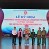 Đại diện tuổi trẻ Thủ đô tặng hoa tri ân lực lượng thanh niên xung phong. (Ảnh: Linh Anh/TTXVN)