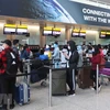 Các công dân Việt Nam xếp hàng chờ làm thủ tục lên máy bay về nước tại sân bay Heathrow. (Ảnh: Đình Thư/TTXVN)