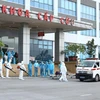 Lực lượng y tế phun thuốc khử khuẩn các công dân khi được đưa về Bệnh viện Nhiệt đới Trung ương cơ sở 2. (Ảnh: Minh Quyết/TTXVN)
