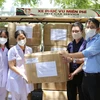 Đại diện Trung tâm Truyền hình Thông tấn và Cơ quan Thông tấn xã Việt Nam Khu vực miền Trung-Tây Nguyên tại Đà Nẵng trao tặng các thùng khẩu trang N95 và đồ bảo hộ y tế cho Trung tâm y tế huyện Hòa Vang. (Ảnh: TTXVN)