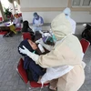 Nhân viên y tế lấy mẫu dịch xét nghiệm COVID-19 cho người dân tại Surakarta, Trung Java, Indonesia ngày 4/8/2020. (Ảnh: THX/TTXVN)