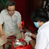 Điều dưỡng Trạm Y tế phường 16, quận Gò Vấp đến nhà lấy máu xét nghiệm cho người bệnh. (Ảnh: Đinh Hằng/TTXVN)