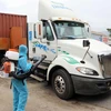 Nhân viên y tế phun thuốc khử khuẩn đối với những xe chở hàng hóa đến từ vùng dịch bệnh tại chốt kiểm soát dịch bệnh số 6 của Thừa Thiên-Huế. (Ảnh: Đỗ Trưởng/TTXVN)