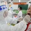 Nhân viên y tế lấy mẫu xét nghiệm COVID-19 tại Handan, tỉnh Hồ Bắc, Trung Quốc. (Ảnh: AFP/TTXVN)