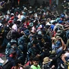 Người di cư Honduras phá hàng rào cảnh sát để vào Guatemala tìm đường tới Mỹ tại khu vực biên giới Corinto, Honduras, ngày 1/10/2020. (Ảnh: AFP/TTXVN)