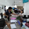 Người dân nộp hồ sơ làm thủ tục tư pháp tại Trung tâm Phục vụ hành chính công tỉnh Tiền Giang. (Ảnh: Minh Hưng/TTXVN)
