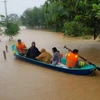 Di chuyển người dân ra khỏi khu vực ngập lũ tại huyện Cam Lộ, tỉnh Quảng Trị. (Ảnh: Thanh Thủy/TTXVN)