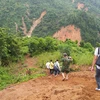 Lực lượng cứu hộ băng rừng Phước Lộc để tiếp cận xã Phước Sơn. (Ảnh: Quốc Dũng/TTXVN)