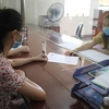 Nhân viên cục thuế tỉnh Ninh Bình hướng dẫn người dân làm thủ tục nộp thuế. (Ảnh: Hải Yến/TTXVN)