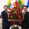 Đại sứ Việt Nam tại Lào Nguyễn Bá Hùng đang trao cho ông Saleumsay Kommasith, Bộ trưởng Ngoại giao Lào lẵng hoa chúc mừng 45 năm Quốc khánh Lào. (Ảnh: Phạm Kiên/VIetnam+)