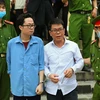 Bị cáo Lâm Hoàng Tùng (áo xanh), bị cáo Nguyễn Hải Nam (áo trắng) sau phiên tòa ngày 30/12/2020. (Ảnh: TTXVN phát)
