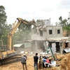 Cưỡng chế tháo dỡ nhà ở xây dựng trái phép trong Khu kinh tế Nhơn Hội. (Ảnh: Nguyên Linh/TTXVN)