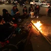 Người dân quây quần bên đống lửa để sưởi ấm trong ngày Đông giá rét. (Ảnh: Phan Tuấn Anh/TTXVN)