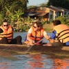 Du khách trải nghiệm đánh cá trên Hồ Lắk bằng thuyền độc mộc. (Ảnh: Nguyễn Tuấn Anh/TTXVN)